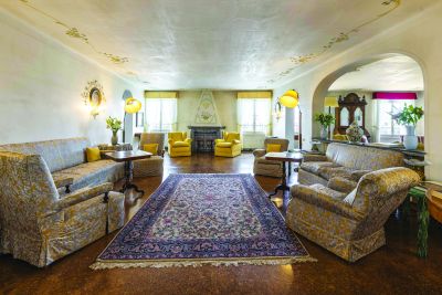 Salone con divani, camino e soffitto decorato